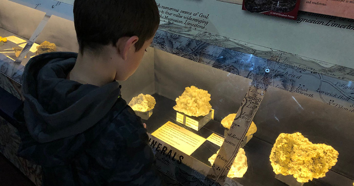 boy looking at minerals inside Killhope Lead Mining museum